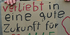 Einer hält das Plakat «Verliebt in einer gute Zukunft für alle»